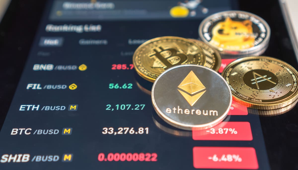 Miljoenen nieuwe cryptomunten mislukten in 2025 en zijn nu niets meer waard Verschillende munten van altcoins, waaronder ethereum en dogecoin, op een telefoon met dalende rode koersen
