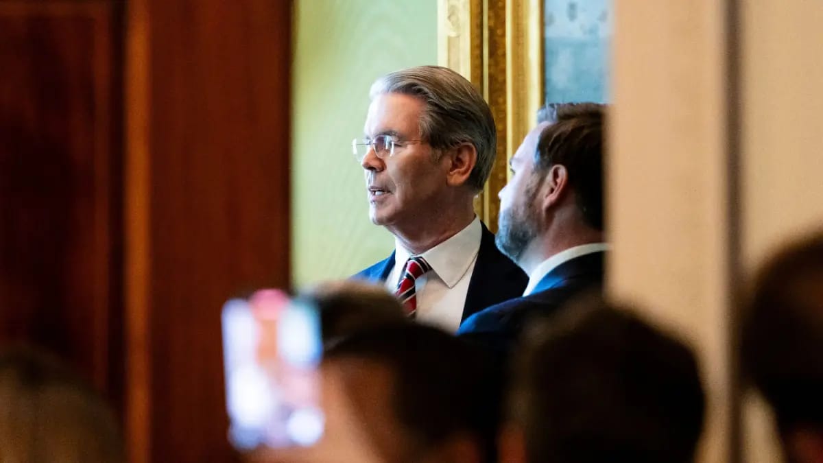 De Amerikaanse president van Financiën, Scott Bessent, te zien in het Witte Huis door een kier in gesprek met JD Vance