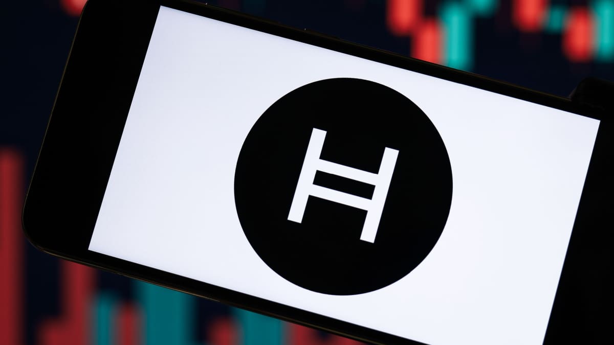 HBAR test cruciale weerstand: uitbraak kan leiden tot 30% stijging Een afbeelding van het logo van Hedera (HBAR) met een grafiek van de koers op de achtergrond