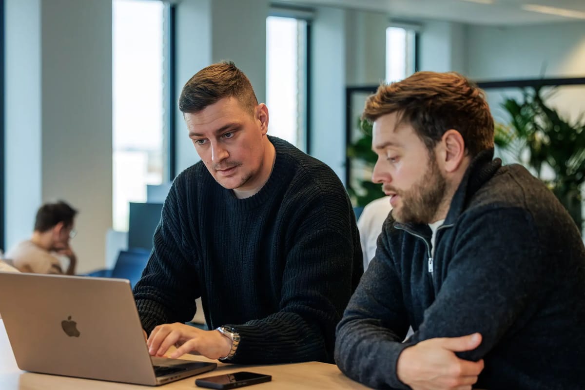 Twee collega's van het Marketing- en Sales-team in gesprek achter het bureau