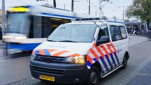 Een politie auto en_of busje in Amsterdam, Nederland, met op de achtergrond een bewegende tram Een politie auto en_of busje in Amsterdam, Nederland, met op de achtergrond een bewegende tram