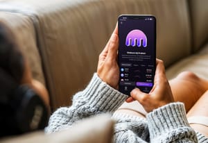 kraken app phone Vrouw op de bank met een telefoon en de kraken app