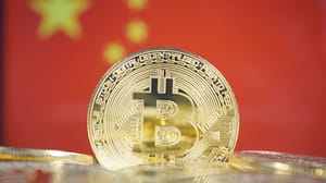 Een aantal bitcoin (BTC) waarvan één rechtopstaand, met op de achtergrond de vlag van china_chinese vlag