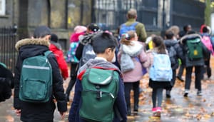 Een afbeelding van een groep schoolkinderen op een rijtje, met een docent_leraar die de stoet begeleidt Een afbeelding van een groep schoolkinderen op een rijtje, met een docent_leraar die de stoet begeleidt