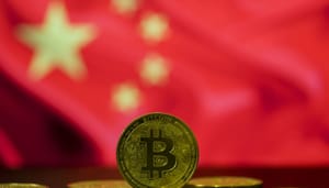 Een bitcoin (BTC) munt op de voorgrond, met op de achtergrond de vlag van China