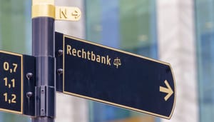 Een afbeelding van een verkeersbord die de richting aanwijst naar de rechtbank
