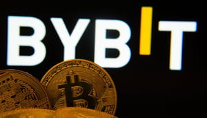Een afbeelding van het logo van cryptobeurs Bybit op de achtergrond, met op de voorgrond een aantal bitcoin (BTC) munten Een afbeelding van het logo van cryptobeurs Bybit op de achtergrond, met op de voorgrond een aantal bitcoin (BTC) munten