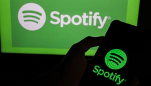 Twee keer het spotify logo met elk een ander contrast, waarvan een op een beeldscherm en een andere op een mobiele telefoon Twee keer het spotify logo met elk een ander contrast, waarvan een op een beeldscherm en een andere op een mobiele telefoon