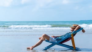 man-op-strand-chillen Man op strandstoel