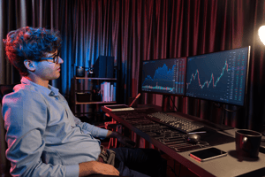 trader-okx-laptop Man op laptop kijkt naar crypto grafieken
