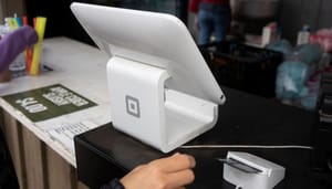 Een afbeelding van een Square betalingssysteem, wat door miljoenen winkels gebruikt wordt Een afbeelding van een Square betalingssysteem, wat door miljoenen winkels gebruikt wordt