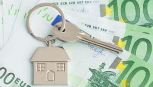 Een afbeelding van een huissleutel met een huis eraan, en op de achtergrond euro bankbiljetten, wat de woningmarkt en de bijbehorende stijgende prijzen moet representeren Een afbeelding van een huissleutel met een huis eraan, en op de achtergrond euro bankbiljetten, wat de woningmarkt en de bijbehorende stijgende prijzen moet representeren