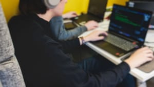 Man koptelefoon achter laptop Ethereum-robot boekt 61% winst - en jij kunt ‘m gratis kopiëren