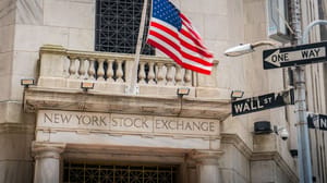 Een afbeelding van de aandelenbeurs van New York, met daarbij een straatbordje met Wall Street