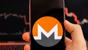 Monero logo op mobiel met koersgrafiek