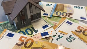Een afbeelding van een huis op een stapel euro bankbiljetten Een afbeelding van een huis op een stapel euro bankbiljetten