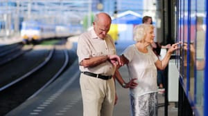 Een afbeelding van een ouder koppel op een treinstation die aan het wachten zijn op het openbaar vervoer Een afbeelding van een ouder koppel op een treinstation die aan het wachten zijn op het openbaar vervoer