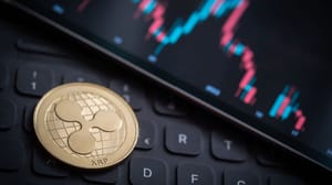 Een afbeelding van de XRP koers op de achtergrond met op de voorgrond een XRP munt, de crypto van Ripple Een afbeelding van de XRP koers op de achtergrond met op de voorgrond een XRP munt, de crypto van Ripple