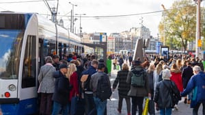 Een afbeelding van mensen die in Amsterdam, de hoofdstad van Nederland, de tram in en uit stappen op het station Een afbeelding van mensen die in Amsterdam, de hoofdstad van Nederland, de tram in en uit stappen op het station