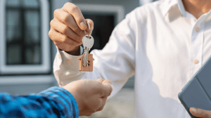 Man overhandigt huissleutels Man overhandigt huissleutels