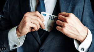 Man stopt eurobiljet in jas Man stopt eurobiljet in jas