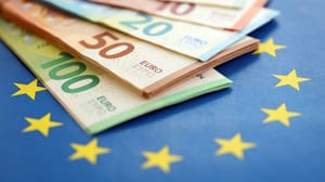 Shutterstock_2638479411 Stapel euro biljetten en EU vlag