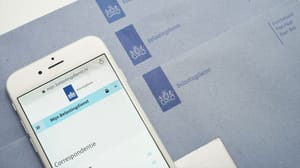 Een afbeelding van 'Mijn belastingdienst' op de Nederlandse overheidssite met blauwe brieven op de achtergrond Een afbeelding van 'Mijn belastingdienst' op de Nederlandse overheidssite met blauwe brieven op de achtergrond