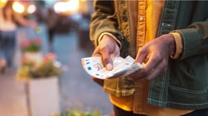 Een afbeelding van een man die euro bankbiljetten van 50 euro vasthoudt in zijn handen Een afbeelding van een man die euro bankbiljetten van 50 euro vasthoudt in zijn handen