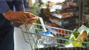 Een afbeelding van een persoon die boodschappen doet in een supermarkt met een winkelkarretje Een afbeelding van een persoon die boodschappen doet in een supermarkt met een winkelkarretje