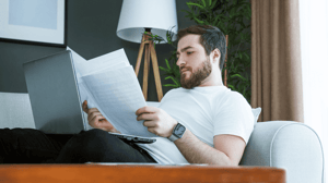 Man zit achterover met papieren en laptop Man zit achterover met papieren en laptop