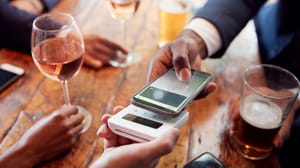 Een afbeelding van een man die met zijn mobiel betaalt in een restaurant Een afbeelding van een man die met zijn mobiel betaalt in een restaurant