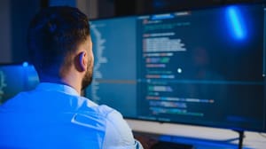 Programmeur kijkt naar scherm met code Ernstig lek in Bitcoin na 1,5 jaar onthuld, kwart netwerk nog kwetsbaar