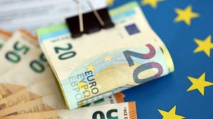 Een afbeelding met euro bankbiljetten op een Europese vlag