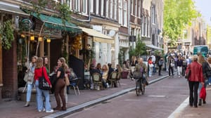 Een afbeelding van fietsende en lopende Nederlanders en toeristen in Amsterdam Een afbeelding van fietsende en lopende Nederlanders en toeristen in Amsterdam