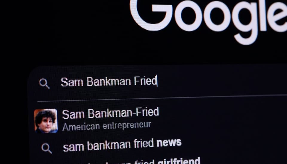 Een computer beeldscherm met de google zoekbalk, waar Sam Bankman-Fried (SBF) is ingevoerd, met verschillende zoeksuggesties