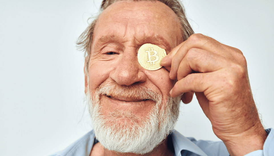 Oudere man met bitcoin munt