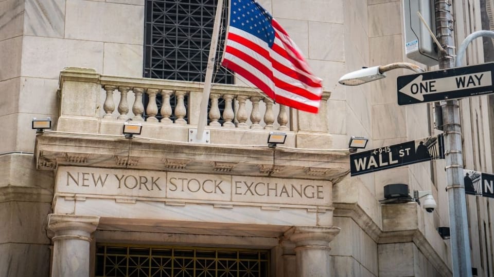 Een afbeelding van de aandelenbeurs van New York, met daarbij een straatbordje met Wall Street