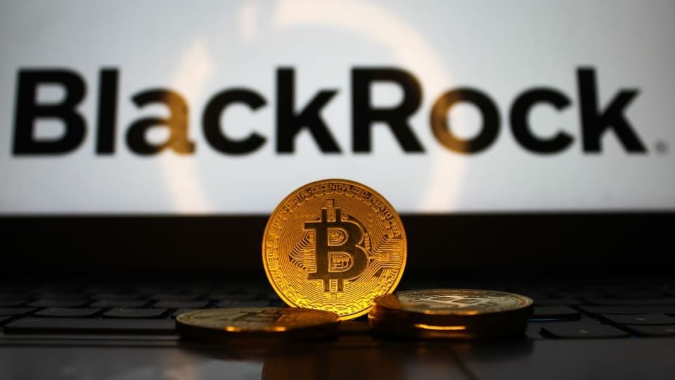 Een afbeelding van fysieke bitcoin munten voor een laptop met het BlackRock logo erop