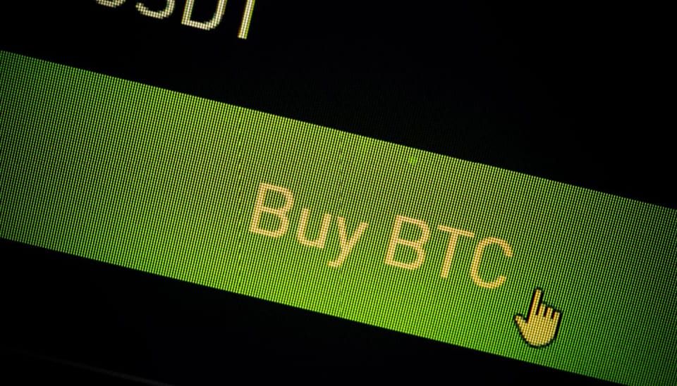 Een close up afbeelding van een 'koop bitcoin (BTC)' knop van een cryptobeurs op een beeldscherm