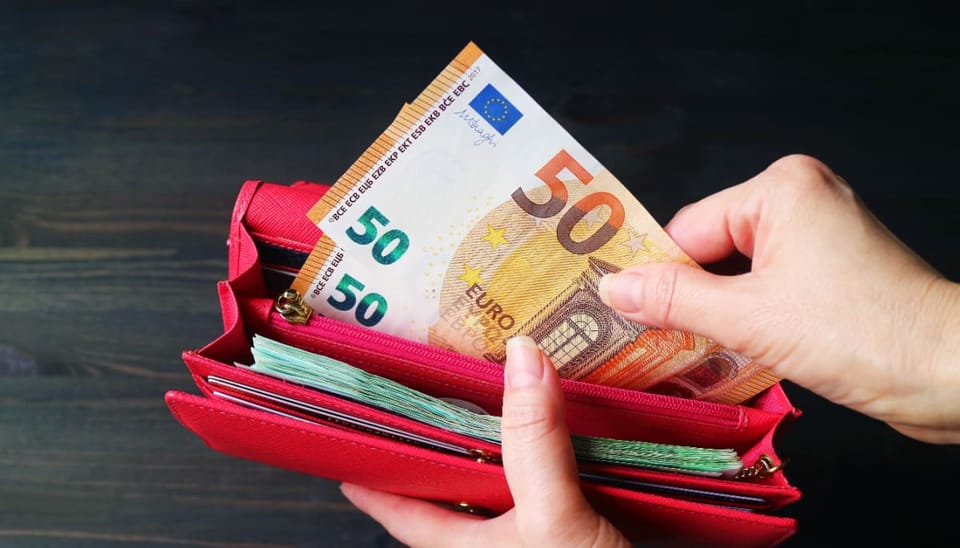 Een afbeelding van geld (euro bankbiljetten) die uit een portemonnee worden gehaald