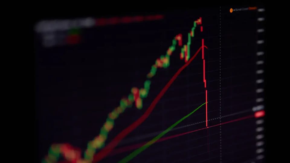 Een afbeelding van een flash crash van een aandeel of crypto koers, met een harde rode lijn direct naar beneden van een candle chart