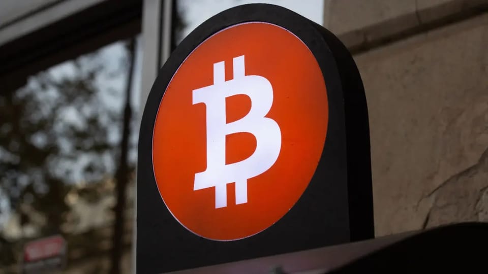 Een afbeelding van het bitcoin logo op een BTC automaat