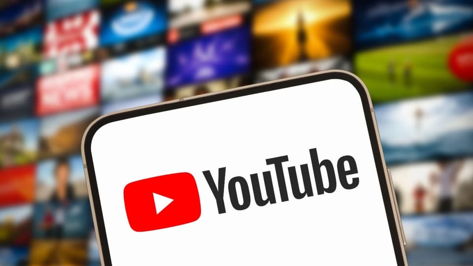 Een afbeelding van het logo van YouTube met op de achtergrond een reeks video's op een scherm