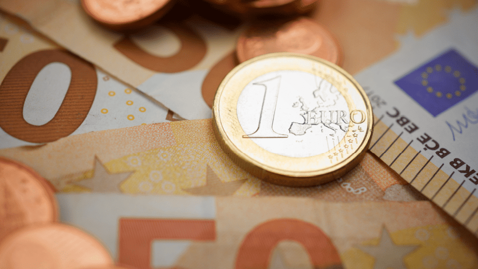 Foto van een euromunt en eurobiljetten