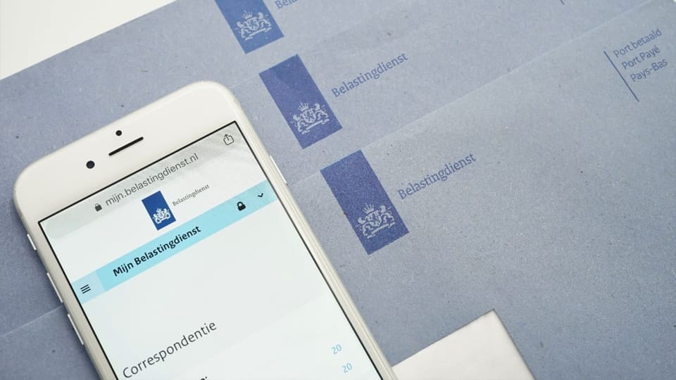 Een afbeelding van 'Mijn belastingdienst' op de Nederlandse overheidssite met blauwe brieven op de achtergrond