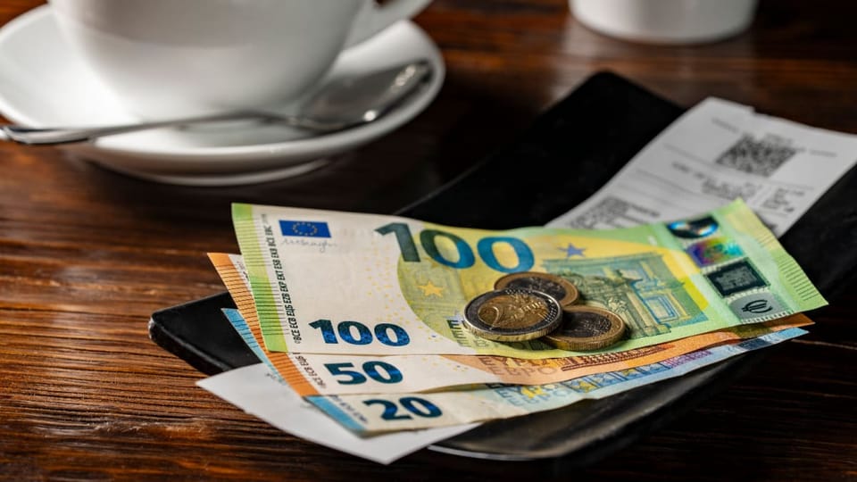 Een fooibakje met contant geld, waaronder 100, 50 en 20 euro biljetten