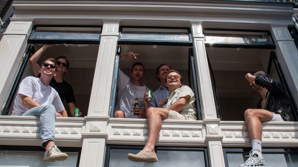 Een afbeelding van studenten in raamkozijnen in Amsterdam