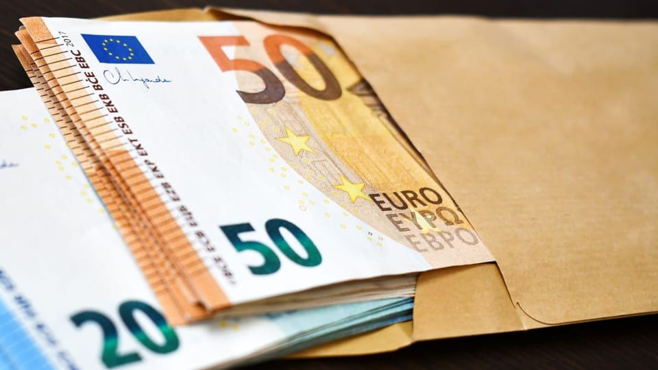 Een afbeelding van vijftig en twintig euro biljetten in een envelop