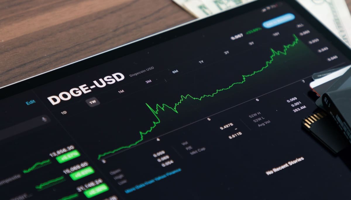 Een afbeelding van een groene stijgende dogecoin (DOGE) koers op een scherm