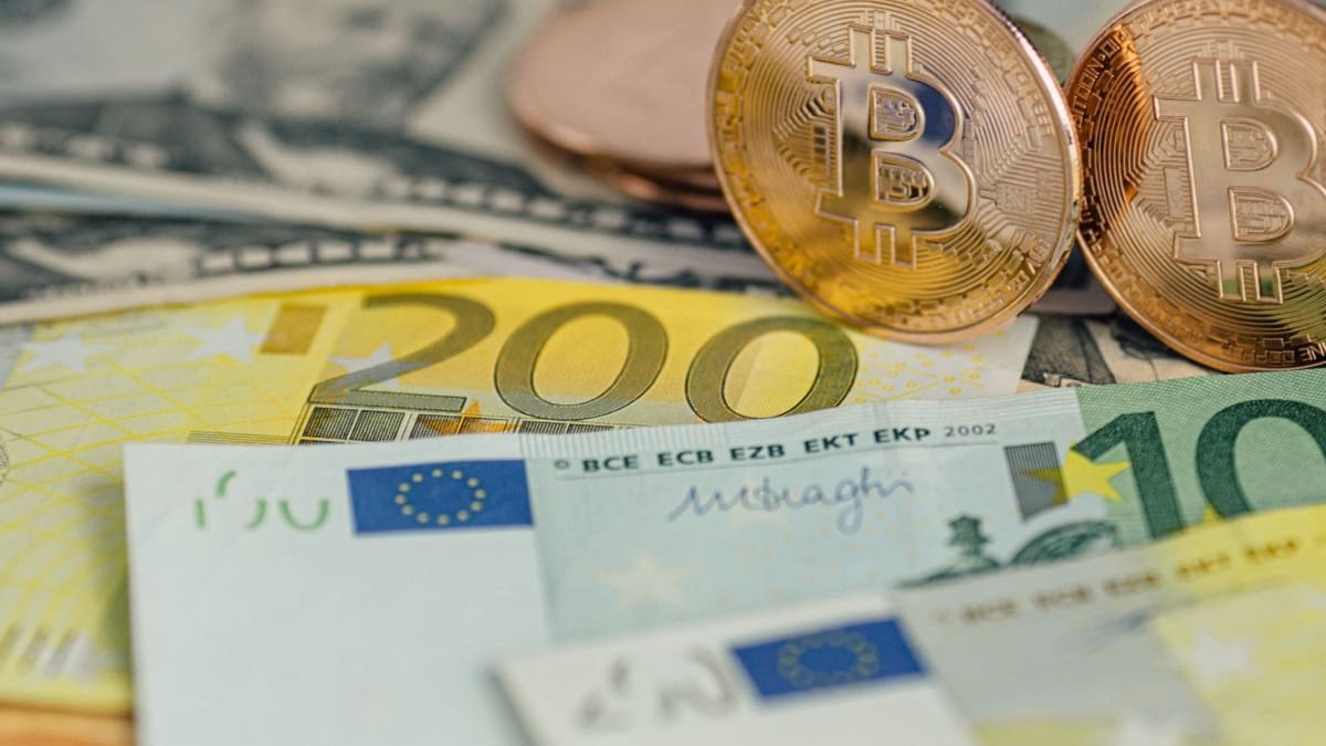 Een afbeelding van fysieke bitcoin cryptomunten op euro bankbiljetten